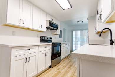 A kitchen with white cabinets and a black oven.